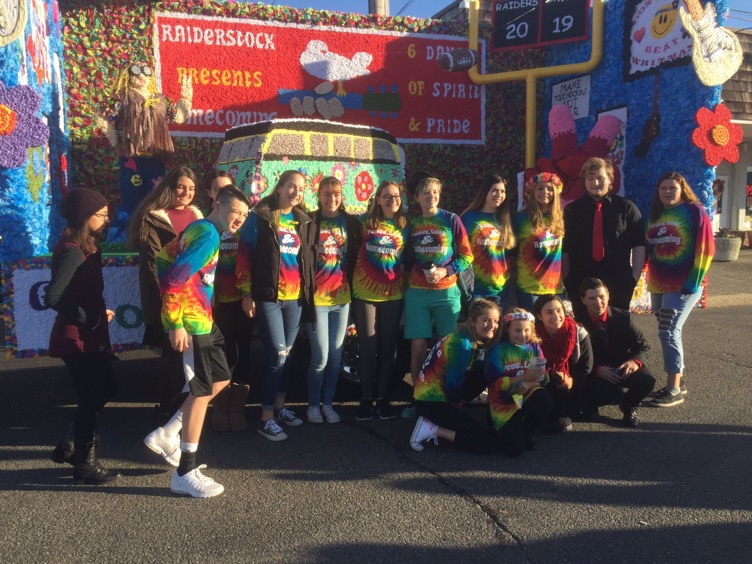 Junior class, in their homecoming shirts, pose in front of their first place float.