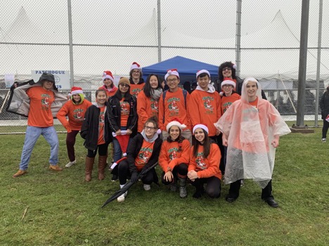 Members of Key Club and Robotics pose with their “Santa’s Helper” shirts on before handing out water to the runners.
