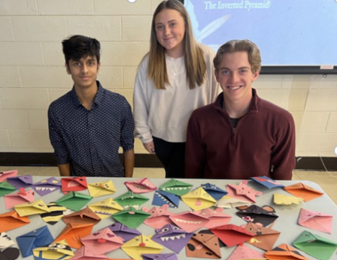 Ohm Patel (LTG), Aurora Dougherty (Secretary), and Bryan Frascogna (President) reveal the creative and unique corner bookmarks made by Key Club members during the Divisional.