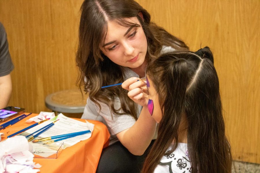 Sarah Biederman set up a face-painting station for kids as part of the entertainment during the NHS Movie Night. 