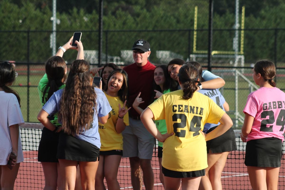 The team takes a celebratory picture with Varsity Coach Molinaro after their 7-0 victory against Bellport.