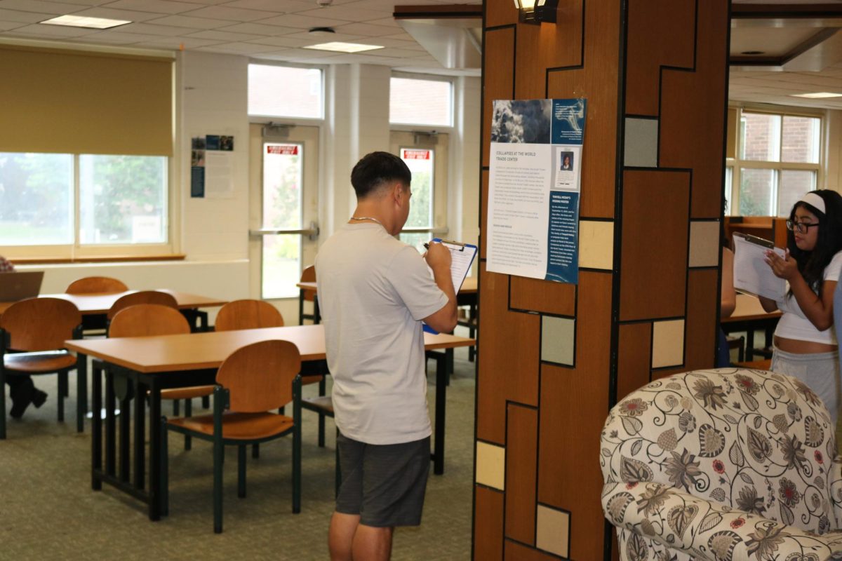 Students move around the library space and read various posters that describe both the events of that day and the aftermath.