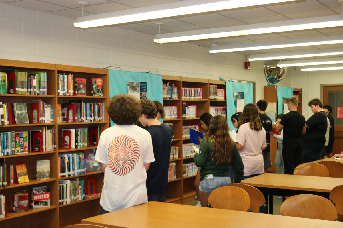 Students are shown reading displays and taking notes on the information they gather about 9/11.