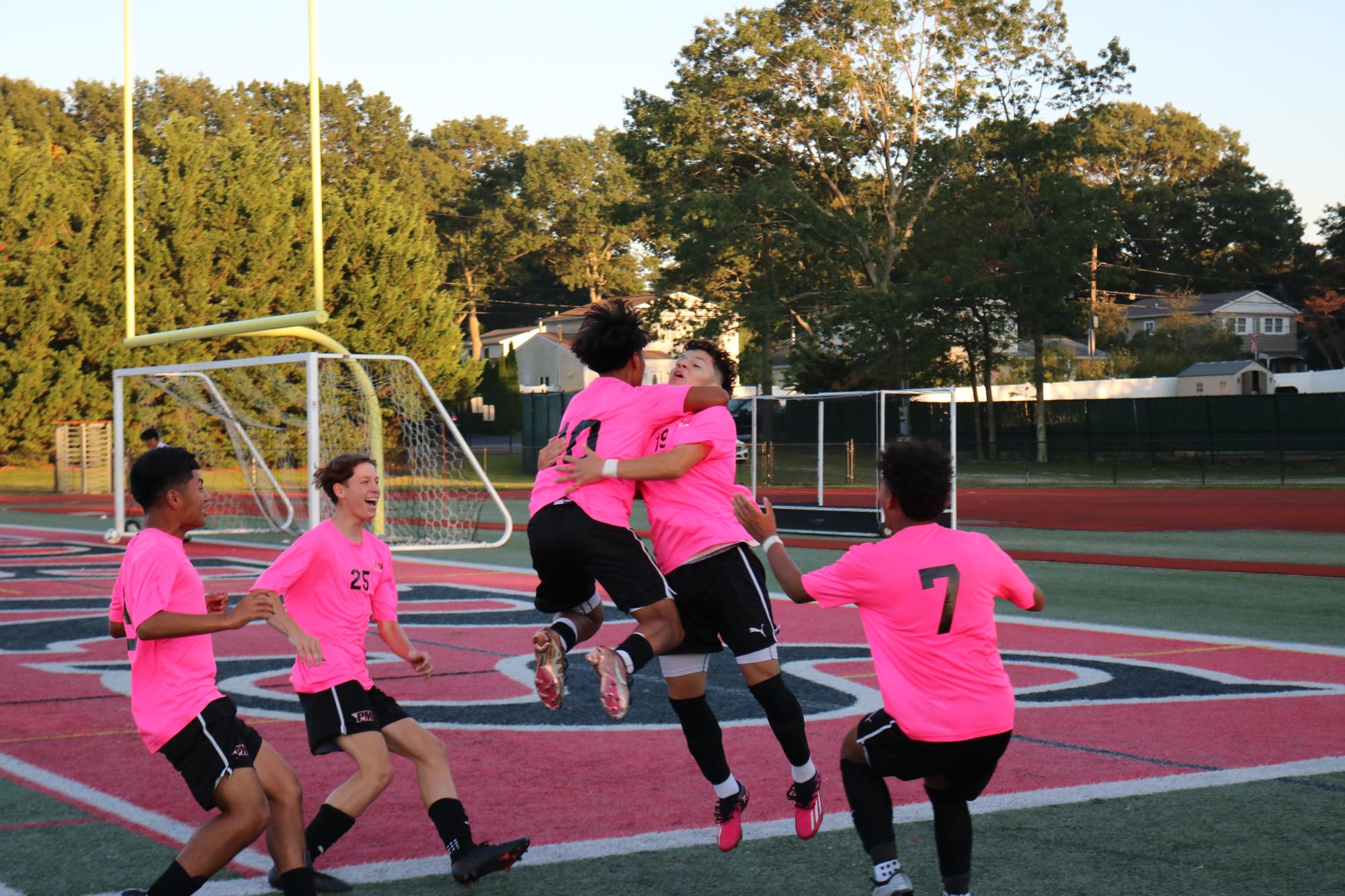 Senior Jasson Guzman (Center, #19) celebrates with his teammates after scoring a goal to secure the Raiders a 5-1 victory against Riverhead.