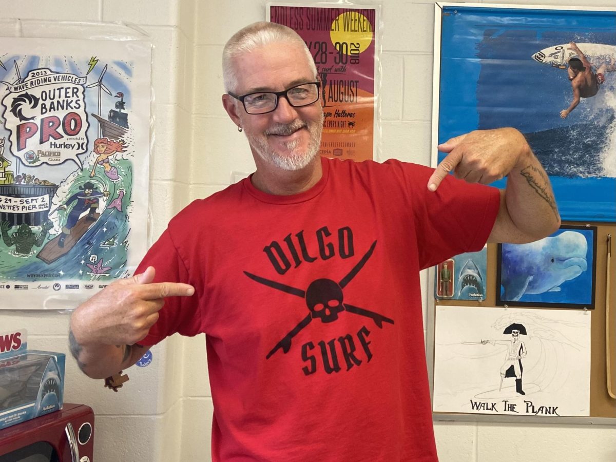 Mr. Schuster showing off a T-shirt from his very own surf-shop brand.