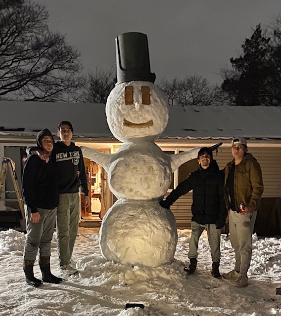 Jorge Perez, a senior who, together with his family, constructed this 11' tall snowman with brick eyes and a garbage receptacle head on the most recent snowy day here in NY.