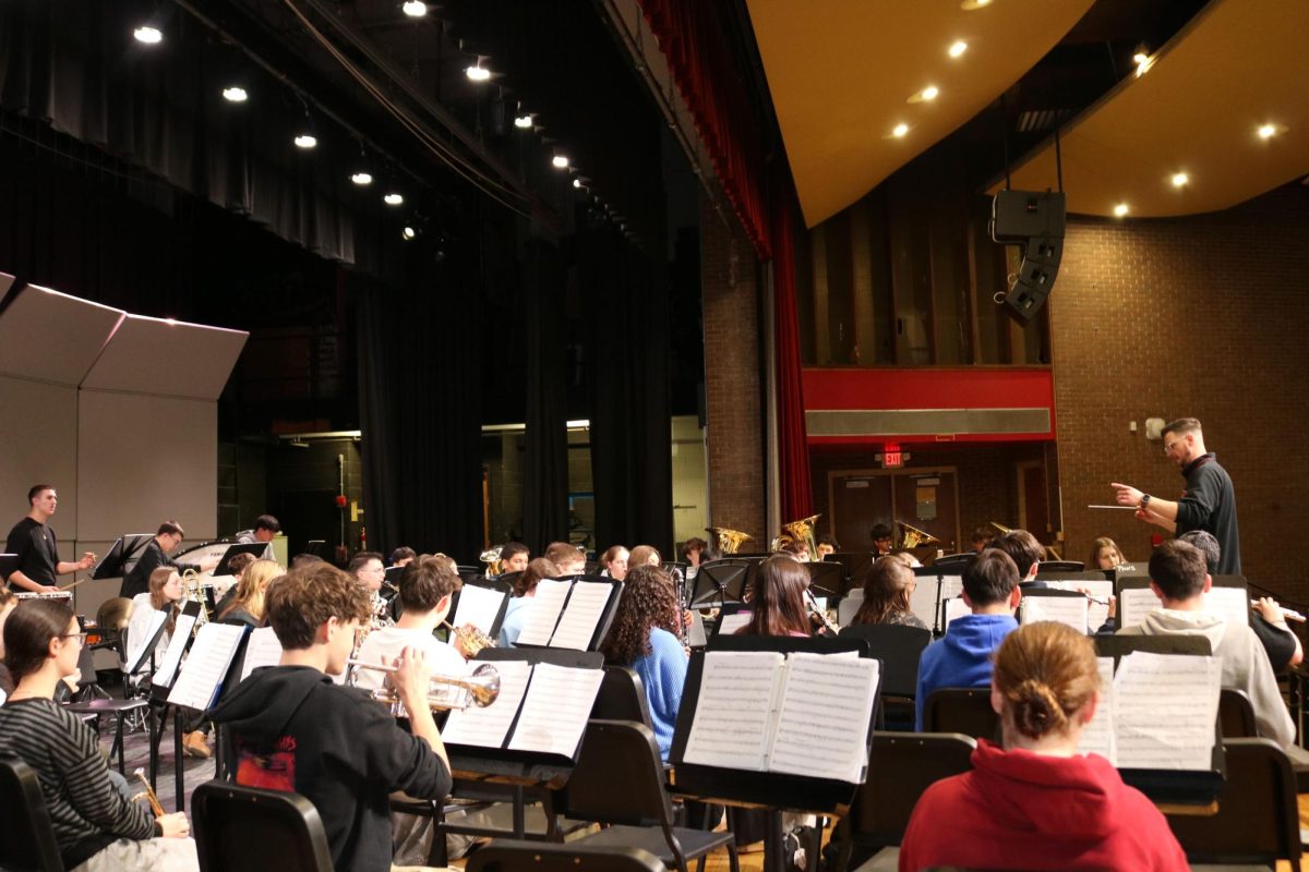  Mr. Thomas Carroll preparing the Wind ensemble for the second POPS concert on March 24th in the high school's auditorium.