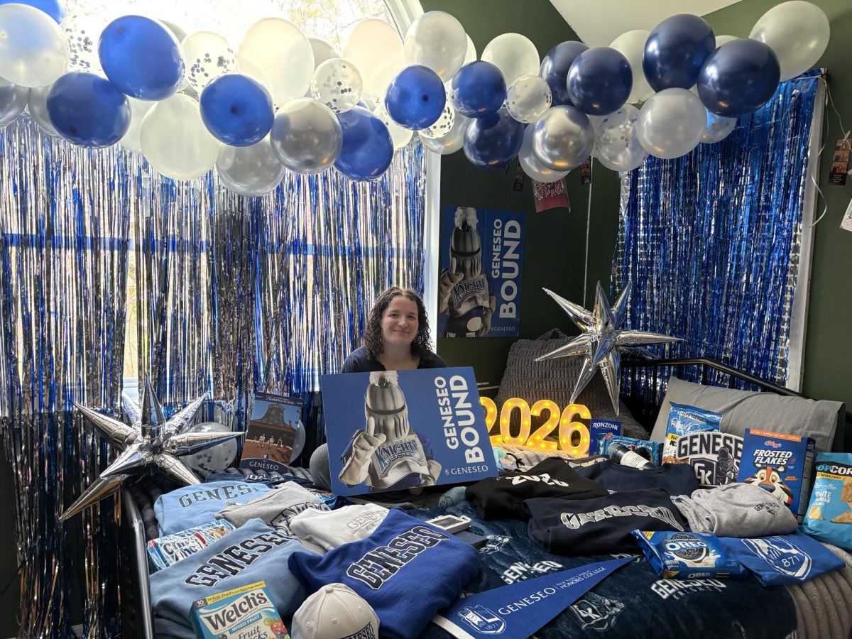 A tradition that many people have started -- here I am sitting on my bed that's covered with SUNY Geneseo merchandise.