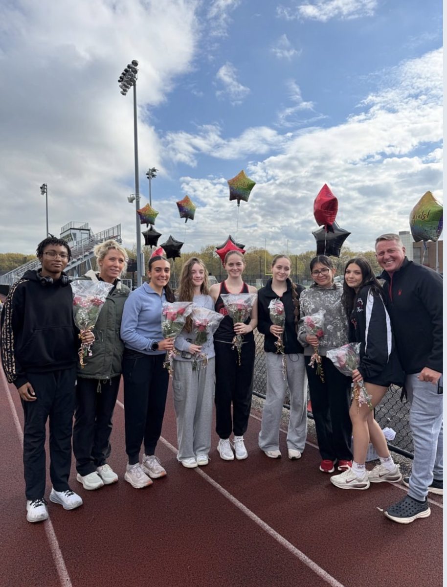 Coach Collins celbrates with the senior members of Varsity Track along with their family members. All senior athletes received recognition prior to the meet.